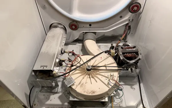 The same dryer cabinet after cleaning: blower housing and heater duct free of lint
